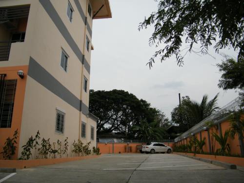 a white car parked in a parking lot next to a building at Fundee 1 Mansion in Ubon Ratchathani