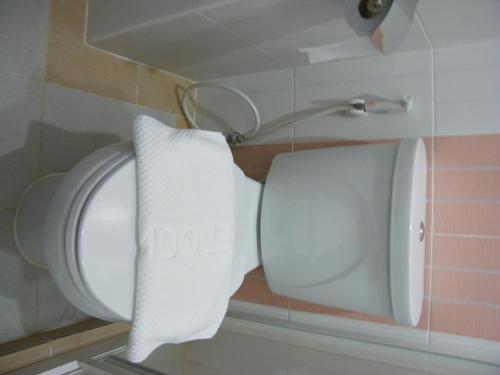 a toilet in a bathroom with a roll of toilet paper at Fundee 1 Mansion in Ubon Ratchathani