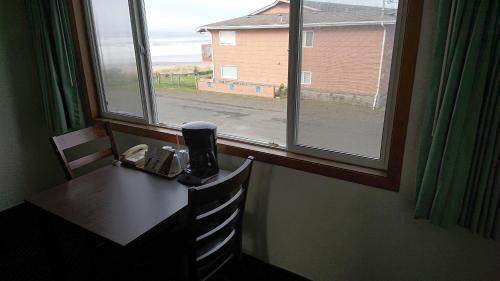 a table and chairs in a room with a window at Silver Sands in Rockaway Beach