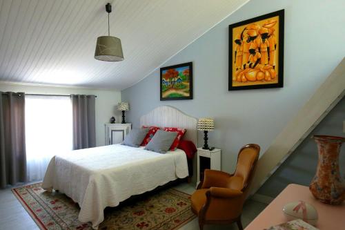 1 dormitorio con 1 cama y 1 silla en La Villa Léa, en Uzès