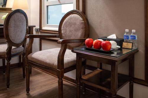 a room with two chairs and a table with apples on it at Alisa Hotel & Spa in Hanoi