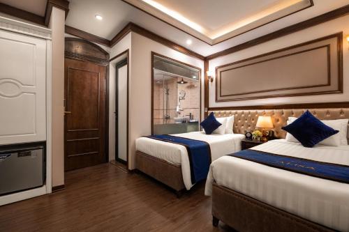 a hotel room with two beds and a tv at Alisa Hotel & Spa in Hanoi