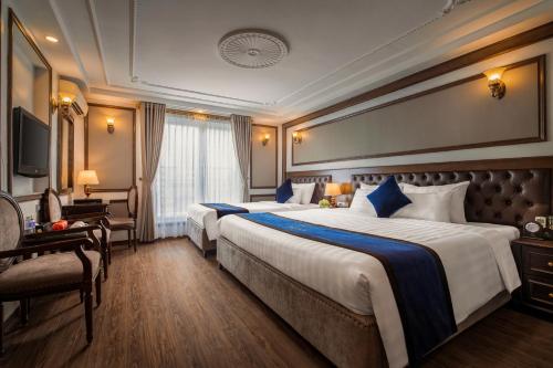 a hotel room with two beds and a television at Alisa Hotel & Spa in Hanoi