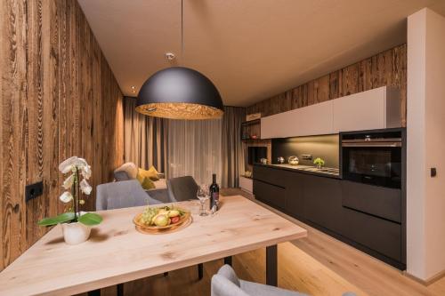 a kitchen with a wooden table with a bowl of fruit at K1 Mountain Chalet - Luxury Apartements in Brunico