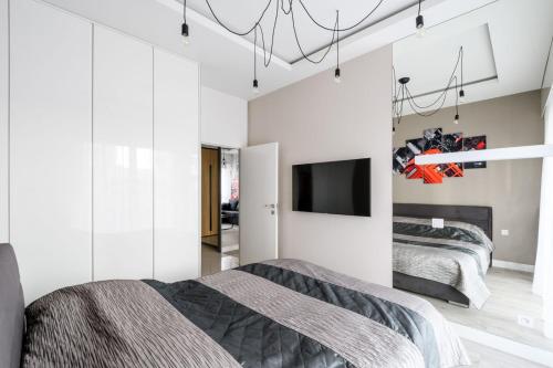 sypialnia z dwoma łóżkami i telewizorem na ścianie w obiekcie Exclusive Trendy Apartments w Warszawie