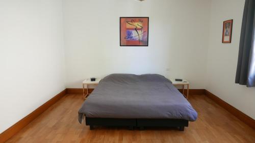 um quarto com uma cama e duas mesas em La maison de Edgar em Ruelle-sur-Touvre