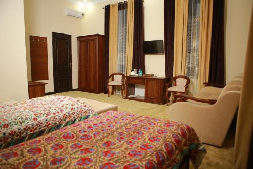 een hotelkamer met een bed, een bureau en stoelen bij Boulevard Palace Hotel in Samarkand