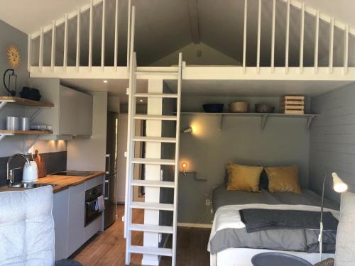 a bedroom with a bunk bed and a kitchen at Lakeview Studio in Stavsjo