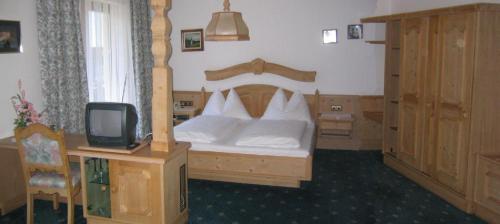 a bedroom with a bed and a small tv at Ferienwohnungen Hauser in Sankt Jakob in Defereggen