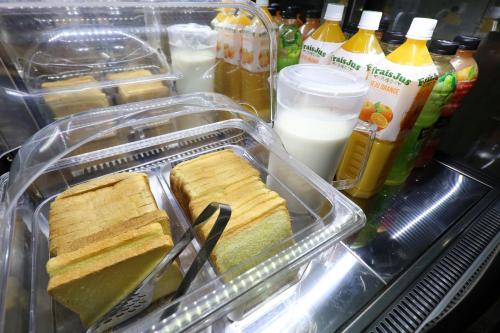 um recipiente de plástico com sanduíches e leite no frigorífico em Xian Hotel em Cheongju