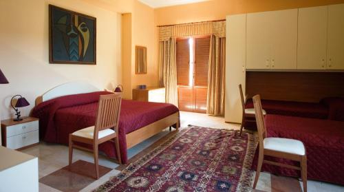 um quarto com 2 camas, uma mesa e cadeiras em B&B Villa Casablanca em Enna