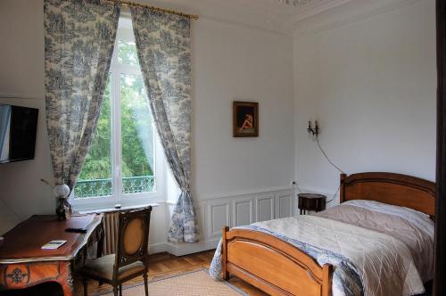 a bedroom with a bed and a desk and a window at Château de broyes in Broyes