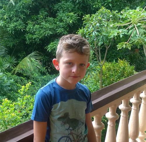 a young boy is standing on a railing at Evergreen in Kandy