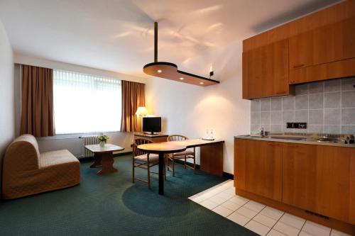 a kitchen with a table and a dining room at LAT Hotel & Apartmenthaus Berlin in Eisenhüttenstadt