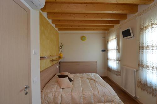 ein Schlafzimmer mit einem Bett und einer Holzdecke in der Unterkunft Garda Dream in Lazise
