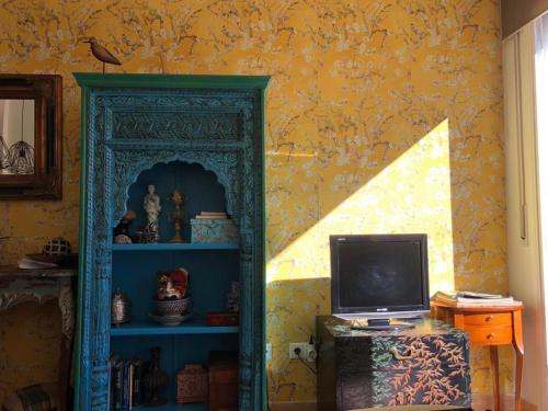 デルテブレにあるAPARTAMENT 4 GATSの青い本棚とテレビが備わる客室です。