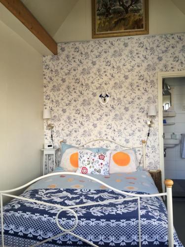 Het Pulletje في Westzaan: غرفة نوم مع سرير وورق جدران