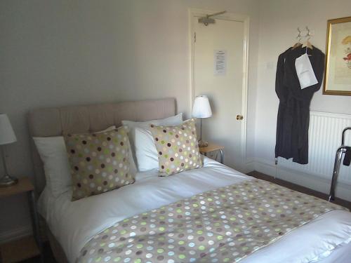 a bed with polka dot pillows in a bedroom at South Lodge Guest House in Bridlington