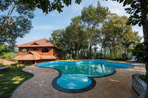 a swimming pool in a yard with a gazebo at Indeevara Retreat, Wayanad in Vythiri