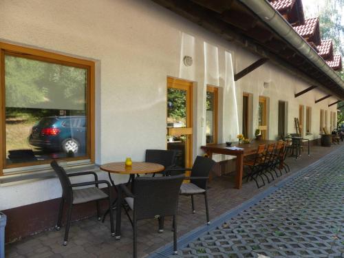 un restaurante con mesas y sillas y un coche en la ventana en Ferienwohnungen Hof Heiderich, en Beerfelden