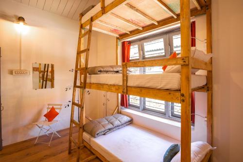 a room with two bunk beds and a window at Zostel Kodaikanal in Kodaikānāl