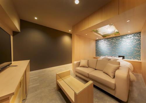 a living room with a couch and a table at HOTEL Eldia Japanese Modern (Adult Only) in Gyōda