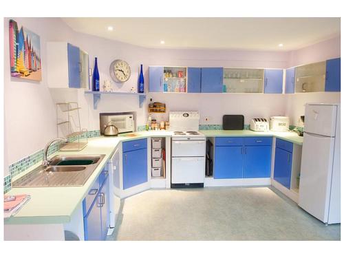 a blue and white kitchen with blue cabinets and appliances at 7 Whinlands in Thorpeness