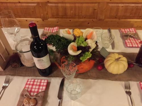 a table with a bottle of wine and a plate of food at Gästehaus Schäfli in Intschi