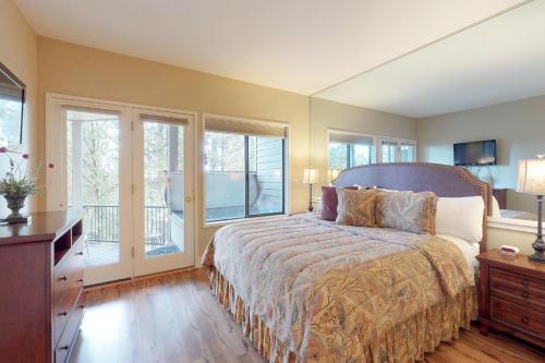 a bedroom with a bed and a desk and windows at Ponderosa Views in Bend