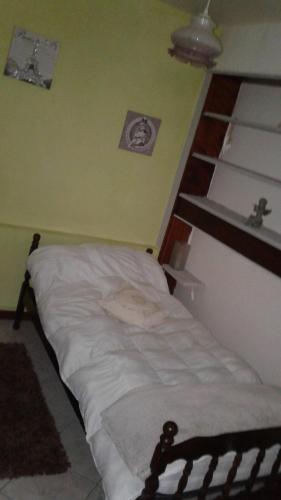 a unmade bed in a room with a shelf at la picarde in Tours-en-Vimeu