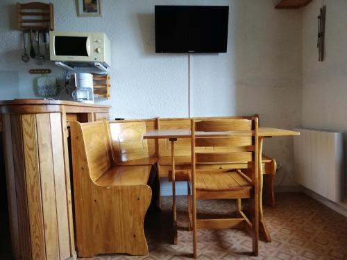 a wooden table with a chair and a television at T2 BARCELONNETTE in Barcelonnette