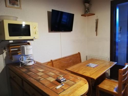 Cette chambre dispose d'une table et d'une télévision murale. dans l'établissement T2 BARCELONNETTE, à Barcelonnette