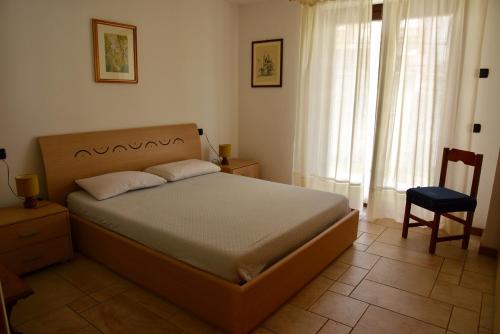 um quarto com uma cama, uma cadeira e uma janela em Baitin Finferlo em Valdidentro