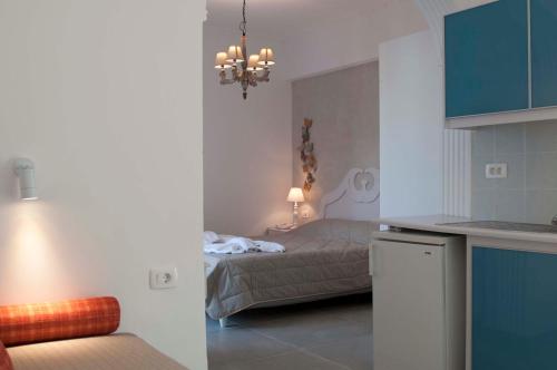 a small bedroom with a bed and a kitchen at Blue Sea Hotel in Kamari