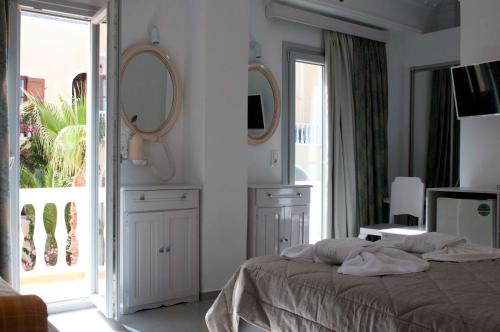 a bedroom with a bed with two mirrors on the wall at Blue Sea Hotel in Kamari