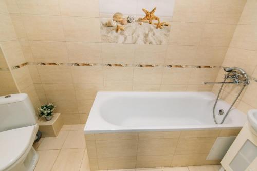 a bathroom with a bath tub and a toilet at Apartmens Faraon Centr 6 floor in Sumy