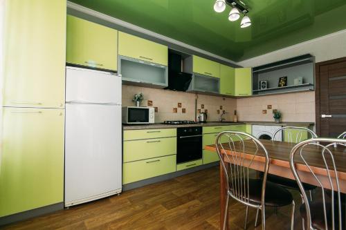 a kitchen with yellow cabinets and a table with chairs at Apartmens Faraon Centr 6 floor in Sumy