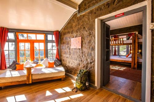 a room with two beds and a stone wall at Zostel Kodaikanal in Kodaikānāl