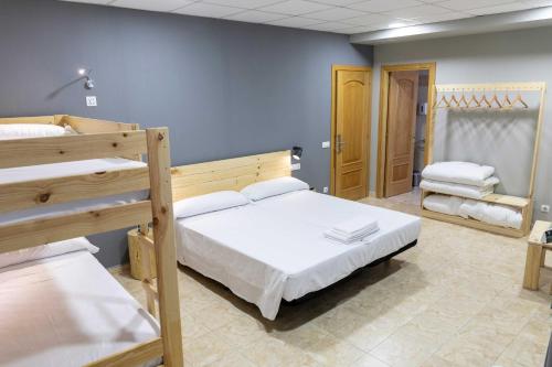 a bedroom with two bunk beds and a hallway at Alda Estella Hostel in Estella