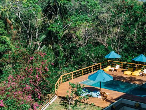 a wooden deck with umbrellas and a swimming pool at Rukgala Retreat in Digana