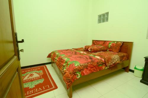 a small bedroom with a bed and a rug at Villa Amanah in Batu