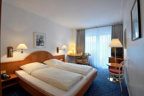 a hotel room with a bed and a desk at Der Kronprinz in Fuhrbach