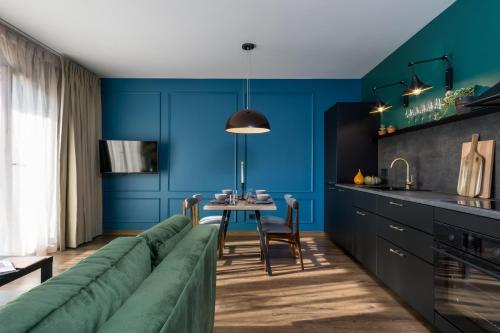 a living room with a green couch and a table at Elite Apartments Oliwa Martinique in Gdańsk