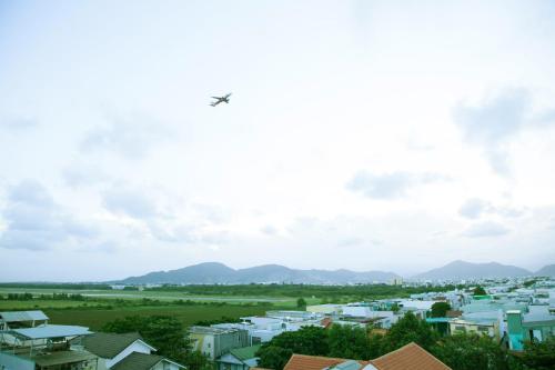 an airplane flying in the sky over a city at Hoang Thuy Sinh Hotel in Da Nang