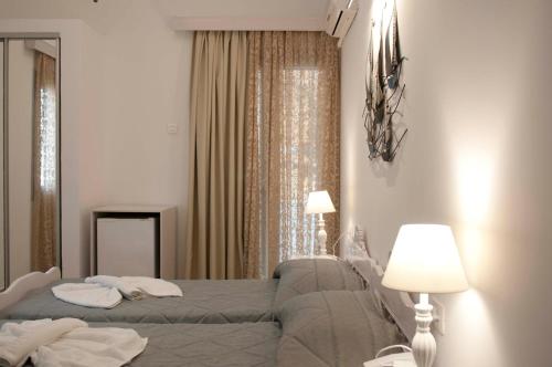 a bedroom with a bed and two lamps and a mirror at Blue Sea Hotel in Kamari