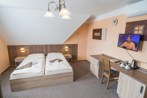 a hotel room with a bed and a desk at Penzion Eduard in Františkovy Lázně