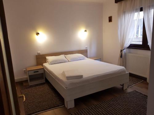 um quarto com uma cama branca e uma janela em Casa Bunicii Sinaia em Sinaia