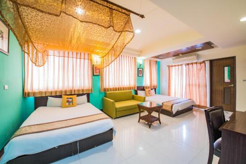 ein Hotelzimmer mit 2 Betten und einem Sofa in der Unterkunft Ribbed Birch B&B in Hualien