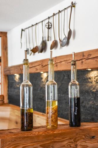 three bottles of oil sitting on a wooden table at Höhengasthaus Kolmenhof an der Donauquelle in Furtwangen