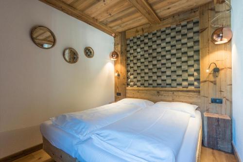 a bedroom with a large bed with a wooden ceiling at Alpine Residence Villa Adler in San Vigilio Di Marebbe